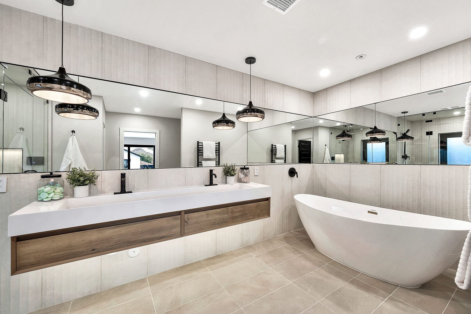 Bathrooms Bathroom with a floating double vanity, mirrored walls and a freestanding bathtub